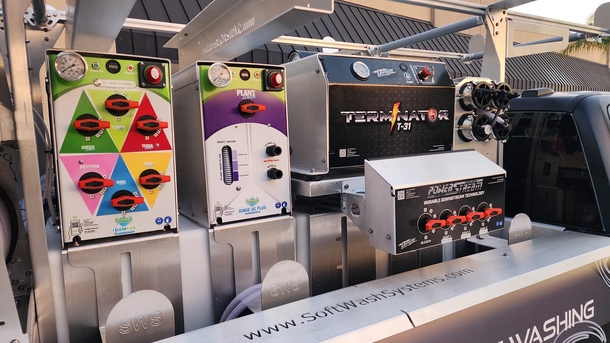 Row of control panels on a car wash system with gauges, red levers, and labels like Plant Wash and Terminator T-31.